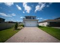 Two-car garage with a paver driveway and manicured landscaping at 16301 Sanctuary Reserve Loop, Clermont, FL 34714