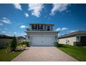 Two-car garage with a paver driveway and manicured landscaping at 16301 Sanctuary Reserve Loop, Clermont, FL 34714