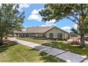 Well-maintained home with a long driveway, showcasing curb appeal and exterior charm at 16500 Quarter Horse Ct, Montverde, FL 34756