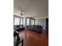 Spacious living room with hardwood floors, ceiling fan, and large windows for natural light at 204 Terrace Ridge Cir # 204, Davenport, FL 33896