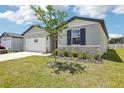 One-story home featuring stone accents, manicured landscaping and lush green lawn at 2141 Rosewood Dr, Bartow, FL 33830
