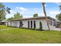 Side view of home featuring well-kept lawn, an arched front door, arched windows, and a one car garage at 2327 Fieldingwood Rd, Maitland, FL 32751