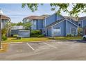 Charming two-story townhouse with blue siding, manicured lawn, and convenient parking spaces at 242 Coco Plum Dr, Davenport, FL 33897