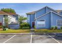 Charming two-story townhouse with blue siding, manicured lawn, and convenient parking spaces at 242 Coco Plum Dr, Davenport, FL 33897
