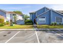 Charming two-story townhouse with blue siding, manicured lawn, and convenient parking spaces at 242 Coco Plum Dr, Davenport, FL 33897