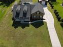 An aerial view of a well-maintained home with a lush green lawn and a long driveway at 2420 Heron Ct, St Cloud, FL 34771