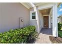 Inviting home entrance with a covered porch, tiled walkway and lush green landscaping at 2423 Datura Loop, St Cloud, FL 34772