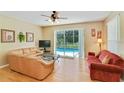 Bright living room featuring hardwood floors, ceiling fan, and a sliding door leading to the pool area at 2918 Sunset Vista Blvd, Kissimmee, FL 34747