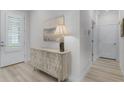 Inviting entryway features a textured wood console table with decor under modern art and light-colored flooring at 3078 Isles Way, New Smyrna Beach, FL 32168