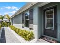 Home exterior features light gray paint, dark shutters, and manicured landscaping at 3078 Isles Way, New Smyrna Beach, FL 32168