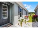Home exterior features light gray paint, dark shutters and beautiful landscaping at 3078 Isles Way, New Smyrna Beach, FL 32168