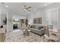Bright living room with neutral furniture, decorative rug, ceiling fan, and a sliding glass door to outdoor seating at 3078 Isles Way, New Smyrna Beach, FL 32168