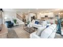 Bright open-concept living room with hardwood floors connecting kitchen and staircase at 3242 Viceroy Ct, Poinciana, FL 34759