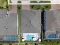 Aerial view showcases a home with a private pool, lush landscaping, and neighboring houses at 3332 Lone Cypress Pt, Oviedo, FL 32765