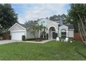 Attractive home with lush green lawn, palm trees, and a two-car garage, offering curb appeal at 3562 Gatlin Pl, Orlando, FL 32812