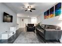 Open-concept living room with stylish gray floors, comfortable leather furniture, and modern art at 3807 Atrium Dr, Orlando, FL 32822