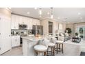 Modern kitchen with granite countertops, stainless steel appliances, island seating and open to living room at 3824 Bluethread Way, Poinciana, FL 34759