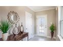 Inviting entryway with decorative mirror, sleek console table, and a glass-paneled front door at 3828 Bluethread Way, Poinciana, FL 34759