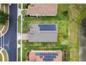 Aerial view of a house roof with solar panels, green lawn, and adjacent neighborhood street at 4469 Biscayne Breeze Way, Kissimmee, FL 34744