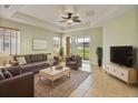 Comfortable living room with neutral tones, ceiling fan, and sliding glass doors to the outside at 4469 Biscayne Breeze Way, Kissimmee, FL 34744