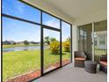 Screened in patio with wicker furniture overlooking a pond and lush landscaping at 4469 Biscayne Breeze Way, Kissimmee, FL 34744
