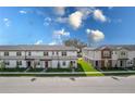 Street view showcasing modern townhomes with well-maintained lawns under a bright blue sky with scattered clouds at 4830 Prairie Preserve Run, St Cloud, FL 34772