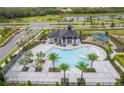 Aerial view of community pool area, featuring a covered pavilion, palm trees, and a playground at 4830 Prairie Preserve Run, St Cloud, FL 34772