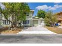 Charming two-story home with green siding, a concrete driveway, and mature trees in the front yard at 522 Boxelder Ave, Altamonte Springs, FL 32714