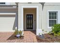 The front entrance showcases a modern door framed by white pillars and red brick walkway at 683 Campo Ln, Davenport, FL 33837