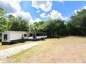 Single-story home featuring a long driveway and a large, tree-filled lot at 736 Guy Rd, Orlando, FL 32828