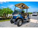 A stylish blue and tan golf cart with a sunshade, perfect for community transport at 743 Driving Range Ct, Reunion, FL 34747
