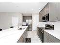 Modern kitchen featuring gray cabinetry, stainless steel appliances, and a large island at 743 Driving Range Ct, Reunion, FL 34747