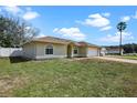 Side view of a tan house with arched windows and a brick paver driveway leading to a two-car garage at 854 Mendoza Dr, Kissimmee, FL 34758