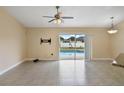 Open living area with tile floors, ceiling fan, and sliding glass doors with view of the pool at 854 Mendoza Dr, Kissimmee, FL 34758