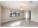 Bright living room featuring tile floors, a ceiling fan, and large windows at 1030 Blue Horizon Dr, Deltona, FL 32725
