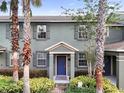 Inviting two-story home boasts a blue door, lush landscaping, and curb appeal at 14743 Driftwater Dr, Winter Garden, FL 34787