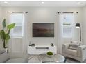 Bright living room with white walls, modern furnishings, and a large screen television at 1929 Tropical Palms Cir, Kissimmee, FL 34747