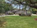 A contemporary home boasts a manicured lawn and mature trees in a suburban setting at 202 Sweetwater Club Blvd, Longwood, FL 32779