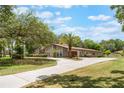 Stunning home with a circular driveway, mature trees, and a meticulously maintained lawn at 202 Sweetwater Club Blvd, Longwood, FL 32779