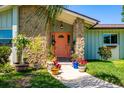 Close up of an inviting front door with stone accents and potted plants at 208 Madeira Ave, Orlando, FL 32825