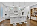 Bright, modern kitchen featuring white cabinets, a center island with seating, and hardwood floors at 2162 Lake Howell Preserve Ct, Maitland, FL 32751
