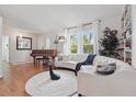 Bright living room boasts a white sofa, hardwood floors, large windows, and a vintage piano at 2277 Clearwater Dr, Deltona, FL 32738