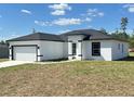 Side view of a modern white home with black trim and a well-manicured lawn at 273 Marion Oaks Golf Rd, Ocala, FL 34473