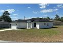 Side view of a modern white home with black trim and a well-manicured lawn at 273 Marion Oaks Golf Rd, Ocala, FL 34473
