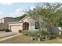 Inviting single-story home featuring a brick driveway, stone accents, manicured landscaping, and a welcoming entrance at 34423 Alameda Dr, Sorrento, FL 32776