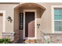 Close-up of a charming front door entrance featuring stone accents, a 