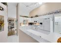 Bright kitchen with white cabinets, white appliances, and an open layout that seamlessly connects to other living spaces at 3661 Kingswood Ct, Clermont, FL 34711