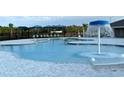 Community pool with shallow entry, splash fountain, and covered seating areas for residents at 3884 Bluethread Way, Poinciana, FL 34759
