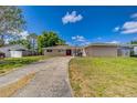 Single-story home with a long driveway, red front door, and well-maintained lawn at 409 Lake Ned Rd, Winter Haven, FL 33884