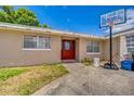 Charming single-story home featuring a bright red front door and a basketball hoop on the driveway at 409 Lake Ned Rd, Winter Haven, FL 33884